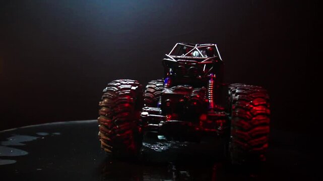 off-road toy cars turn with big tires art creative in water splashes 360 degree rotation on dark background with red backlight