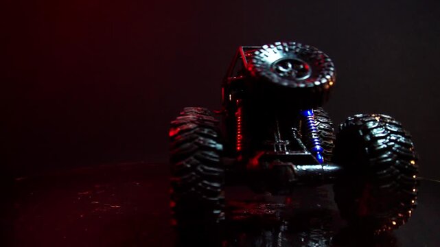 off-road toy cars turn with big tires art creative in water splashes 360 degree rotation on dark background with red backlight
