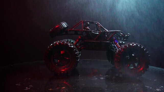 off-road toy cars turn with big tires art creative in water splashes 360 degree rotation on dark background with red backlight