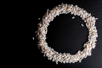 Obraz premium Letter O shaped from white rice on a black background, ideal for culinary typography, grain branding and modern alphabet design concepts