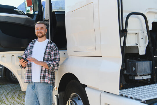 Truck driver using smartphone next to semi truck