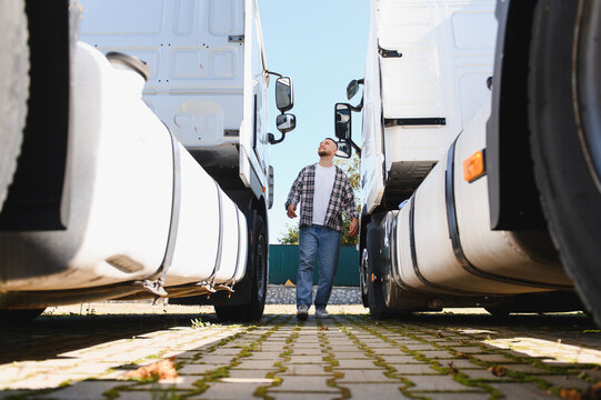 Truck driver walking between semi trucks inspecting fleet