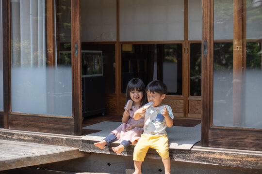 古民家の縁側でアイスを食べる子供達
