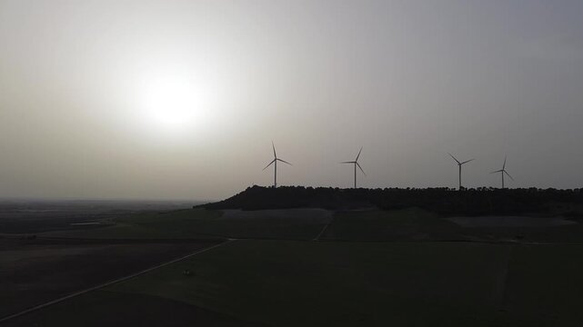 Wind turbines silhouettes in dusty sunset sky with copy space &ndash; renewable energy concept