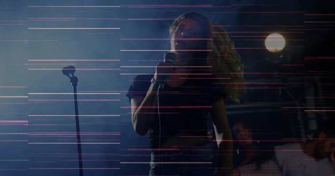Lead vocalist stepping toward handheld mic singing for music tossing hair magenta lines streaking