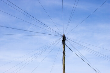 Fototapeta premium Telephone poles with cable connection against blue skies