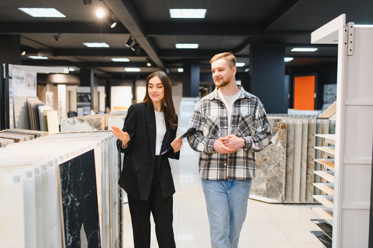 Sales consultant helping male customer choosing floor tiles