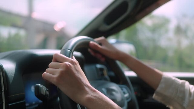 Close-up of female driver's hands on steering wheel, focusing on safe driving and control. Ideal for car insurance, transportation, road trip, and travel lifestyle concepts.