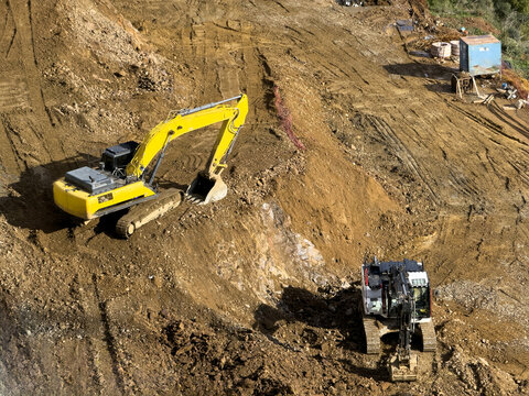 View of yellow excavators digging into the earth, creating a scene of industrial activity against the backdrop of bare land, Sariyer, Istanbul, Turkey.