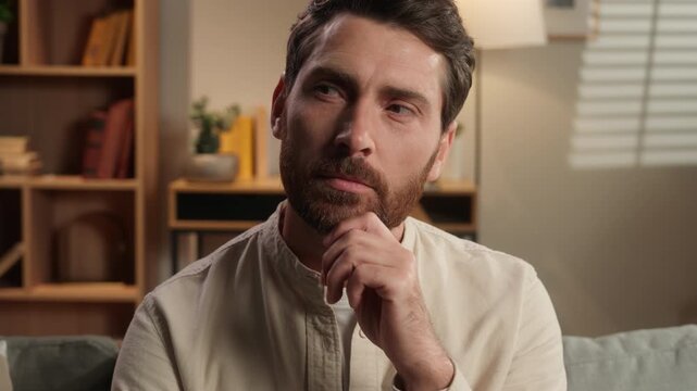 Portrait pensive satisfied clever Caucasian middle-aged man thoughtful thinking smiling at home bearded adult male think deep in thoughts hesitation brainstorming idea puzzled in domestic living room