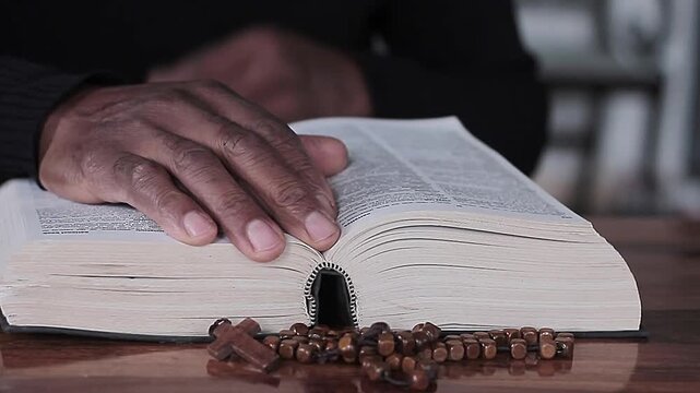 praying to God with hand's together with cross on table with people and black background stock video stock footage