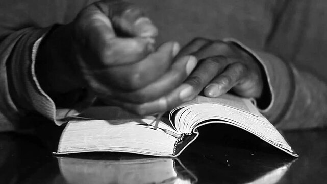 praying to God with hand's together with cross on table with people and black background stock video stock footage