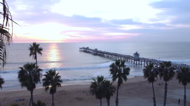 San Clemente, California. Pan to end of Long Coastal Pier Overlooking Horizon at Sunset. Looking North to Dana Point, Orange County.