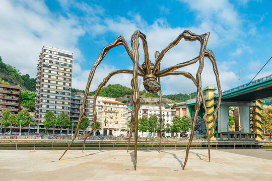 Bilbao, Spain - September 18, 2022: Maman spider sculpture by Louise Bourgeois in front of Guggenheim Museum Bilbao with urban surroundings and riverfront, Bilbo, Basque country. Contemporary art