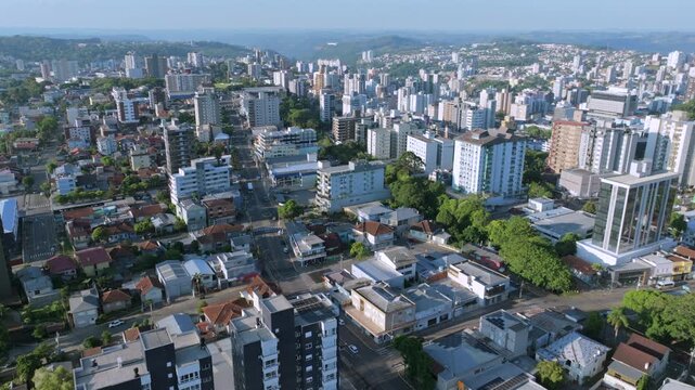 Bento Gon&ccedil;alves aerial hover above urban neighborhoods and skyline with layered hills, captured in D-Log with 10-bit color using a Hasselblad sensor.
