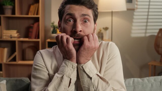 Portrait Caucasian middle-aged man scared afraid emotion looking at camera at couch at home adult male feeling terrible frightened stress panic attack anxious worried problem in living room scary fear