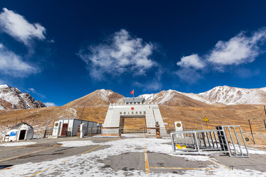 Khunjerab, Pakistan - 05 November 2020: View of the iconic Khunjerab Pass border gate under a brilliant blue sky, framed by snow-dusted mountains and the stark, open landscape.