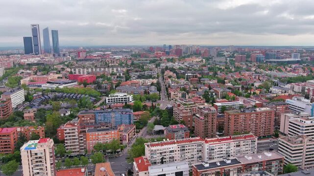 Aerial view of Madrid, Spain skyline with dense urban architecture, residential districts and modern cityscape under cloudy sky, showcasing European capital life, travel, real estate and city footage.