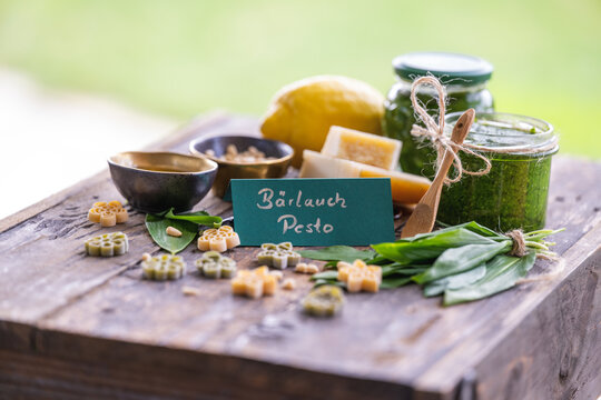 Frisches selbstgemachtes B&auml;rlauchpesto dekoriert mit B&auml;rlauchbl&auml;ttern, Hartk&auml;se, Pinienkernen, nudeln, oliven&ouml;l,einer Zitrone und einem gr&uuml;nen handbeschrifteten Schild