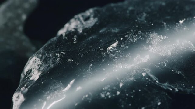 White glowing fracture through icy black rock texture