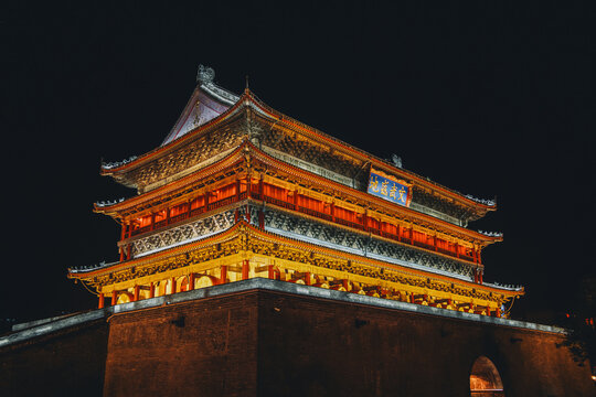 View of the illuminated Bell Tower with its layered, traditional architecture glowing against the night sky, Xi'An, Shaanxi, China.