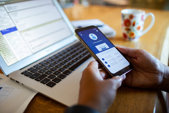Person using mobile banking app at home office desk