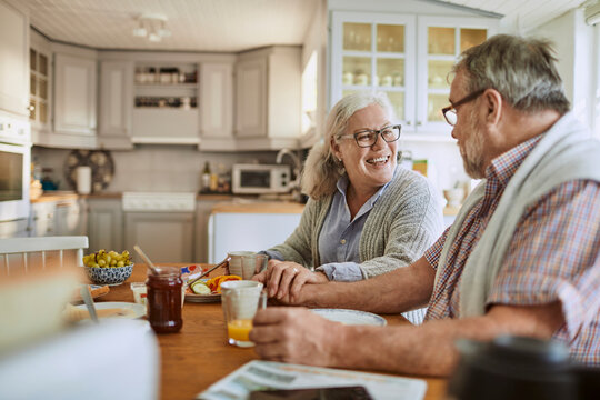 Smiling senior couple enjoying breakfast together at home