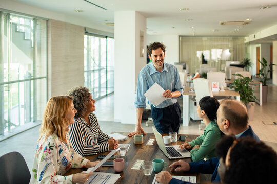 Business team meeting with leader presenting in modern office
