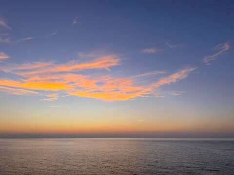 Dusk sky over calm ocean.