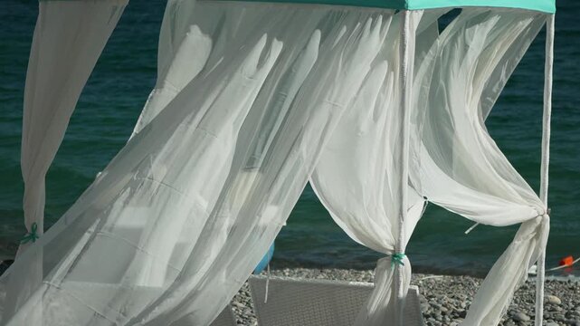 Bungalows sea. Beach Lounge bed with white silky curtains. Lounge bed with canopy at seaside. Beach Chairs and Sunshades. Summer Vacation resort concept.
