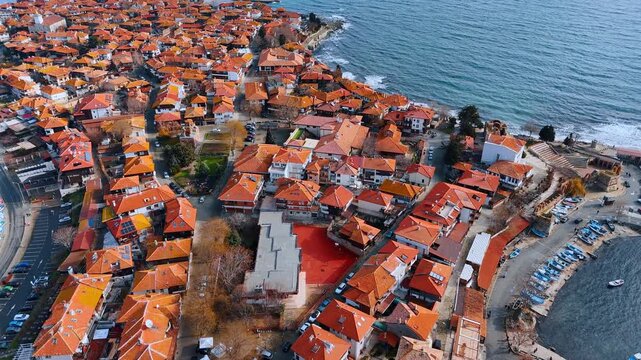 Wide aerial view of old town peninsula and sea. High angle panoramic view of a densely built old town with red roofs surrounded by the black sea.