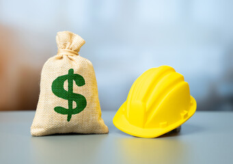 The dollar is a money bag and a yellow construction worker's hard hat. Investments in real estate and infrastructure construction. Capital drives development. Urban growth and industrial expansion