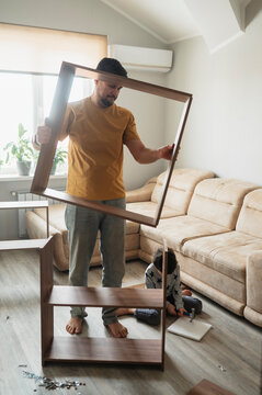 Dad and child assembling furniture together in modern living room