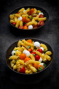 Pasta salad with mozzarella tomato and basil in a bowl