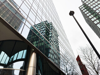 Reflections on a glass office tower in London, UK with modern skyscraper architecture and urban perspective