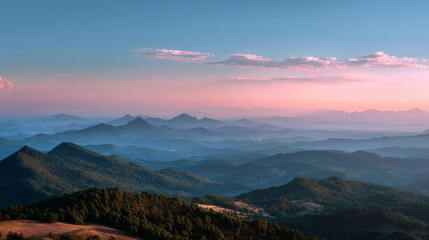 Fototapeta premium Soft haze covers distant mountain range under pastel sky at sunset, tranquil and serene landscape