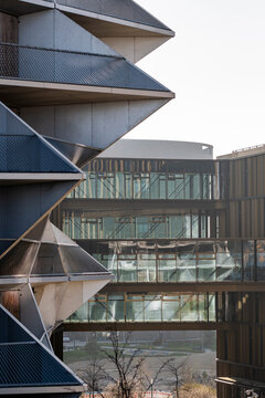 Angular modern building with balcony geometry where concrete and steel create an urban facade pattern of sharp lines and repeating structural forms in abstract design