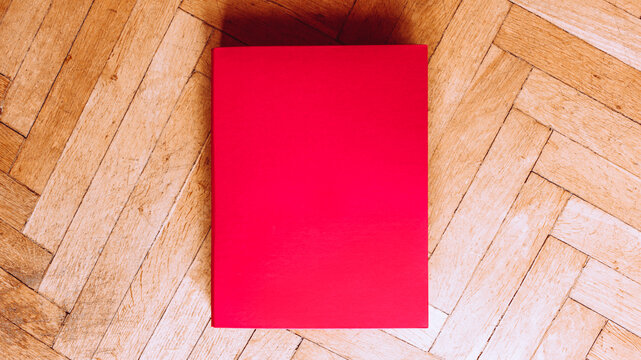 Pink binder top view on brown laminate floor background
