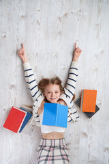 Cute girl reading colorful books. Learning and reading with fun - concept.