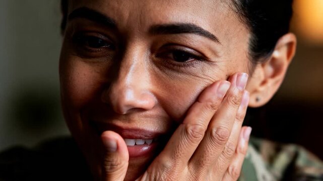 Noticing tear, soldier in camouflage uniform in lounge pressing finger to inner eye, steadying self