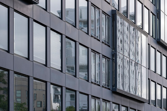 Clean modern architecture detail showing office building facade with glass windows reflections and geometric pattern for abstract corporate background