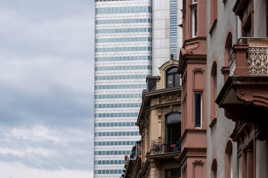 Architecture contrast in Frankfurt Bankenviertel Germany with historic facade row leading toward modern skyscraper skyline in the distance
