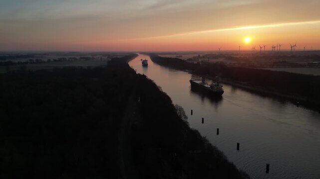 Schiffe fahren bei Sonnenaufgang im Nord-Ostsee-Kanal