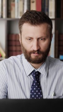 Backache. Vertical orientation of bearded man in workplace getting up from chair and experiencing lower back pain. Osteochondrosis, kidney stones concept