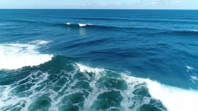 A seamlessly looping aerial view of a blue ocean surface reveals the continuous, rhythmic movement of open-water waves against a natural sky.