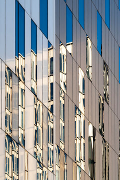 Blue modern office building architecture facade with windows grid and crisp lines creating an abstract pattern for clean design background