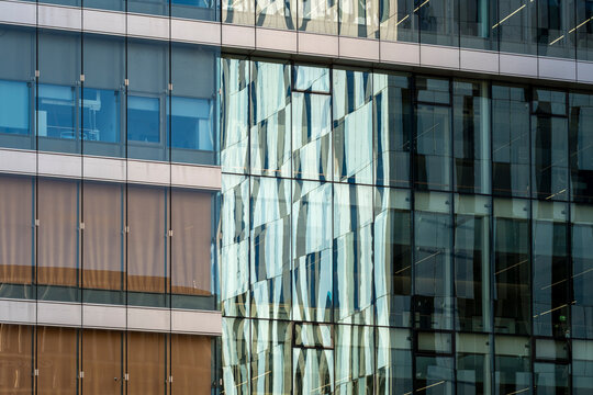 Modern office building architecture facade with layered glass windows and reflections adding depth while forming an abstract pattern design background