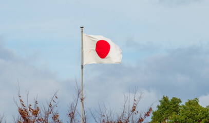 Japanese flag waving on the blue cloudy sky