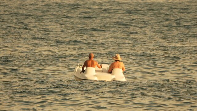 People, pedal boat, ocean two people enjoying a relaxed summer vacation on a pedal boat