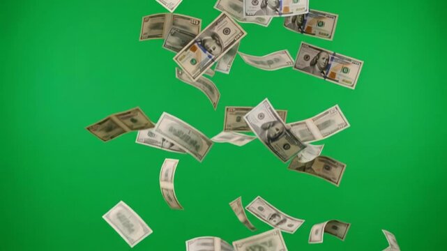 Us hundred dollar bills falling against a vibrant green screen, symbolizing financial downfall and bankruptcy.